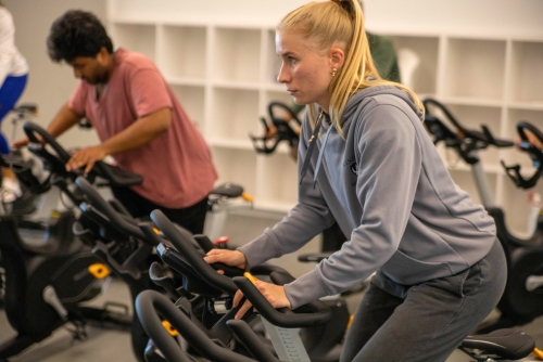 Participants ride spin bike during a fitness class.