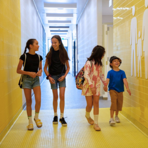 Children walk down changeroom hallway