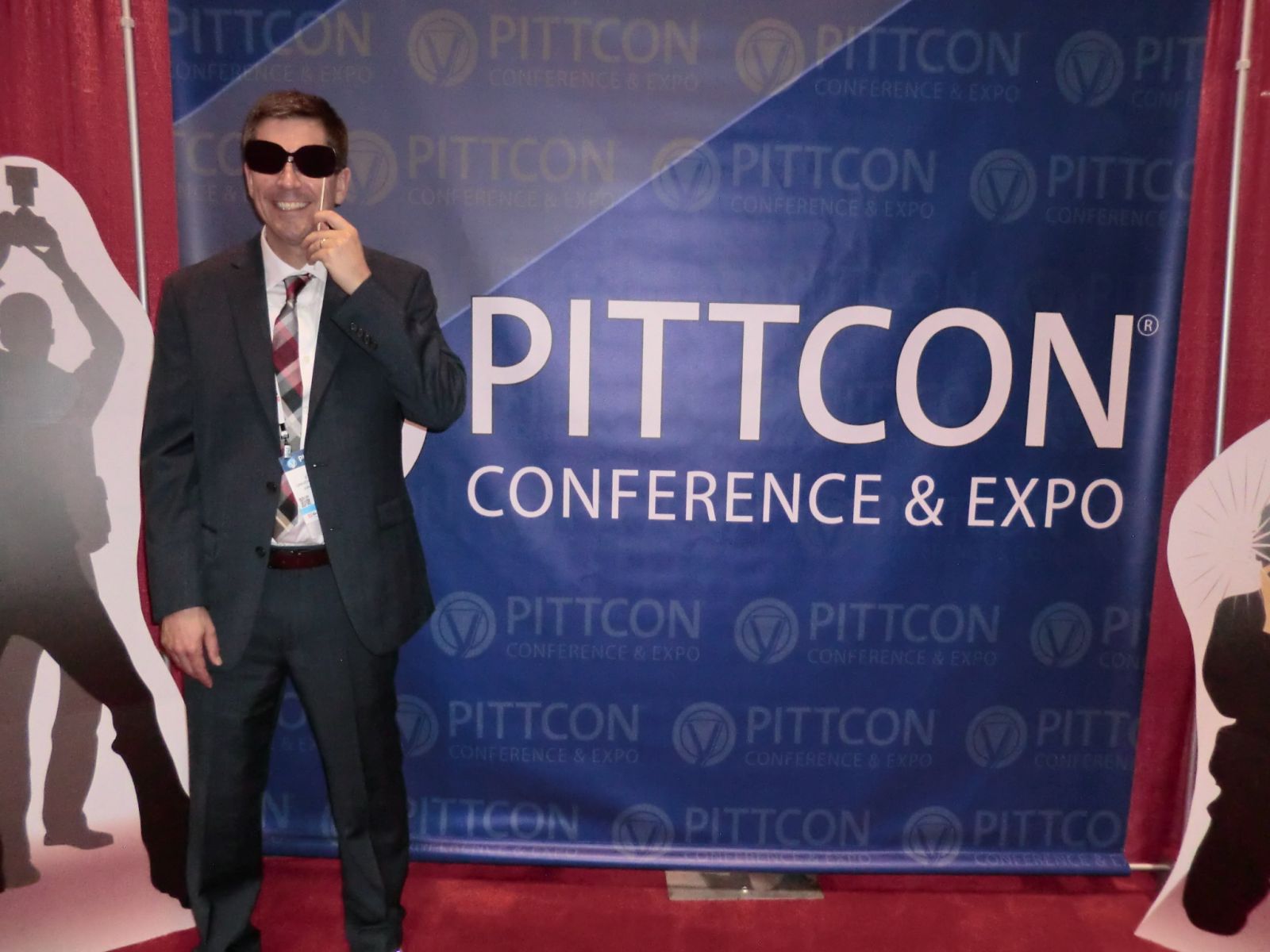 Dr Rehse posing in front of PITTCON Conference backdrop