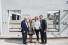 The Rodziks stand in front of a concrete panel of the new six story residence