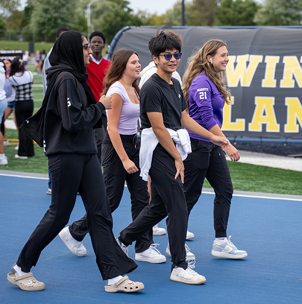 Assumption students walking on Alumni Stadium track