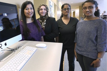 Women standing by computer monitor