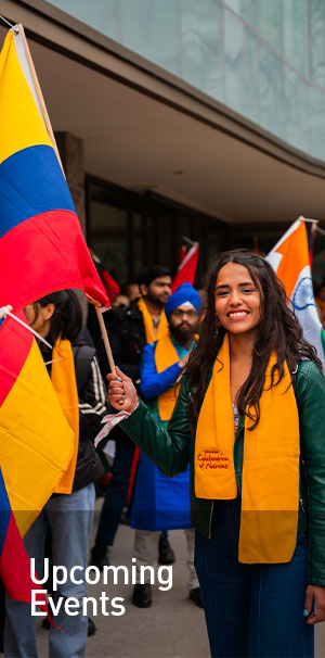 Female student holding flag smiling at camera