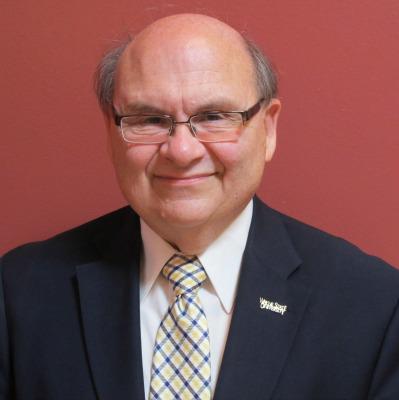 Dr. Peter Frade with a faded red background behind him. 