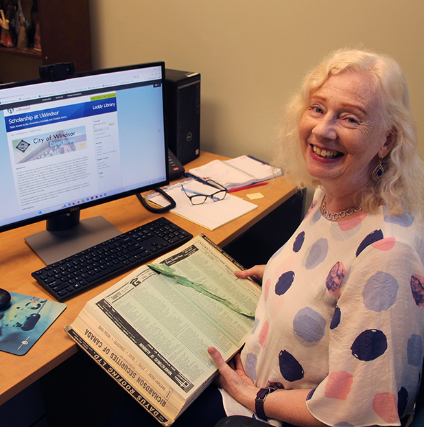 Katharine Ball holding a print copy of the city directory