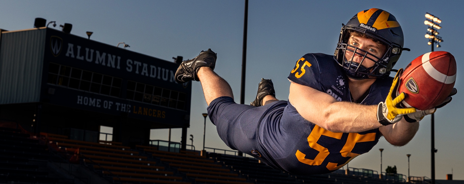 receiver stretching to catch football