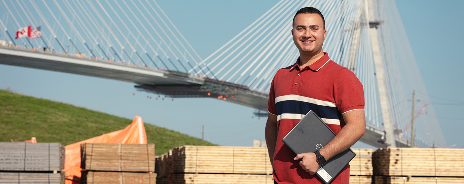 man stands in front of bridge