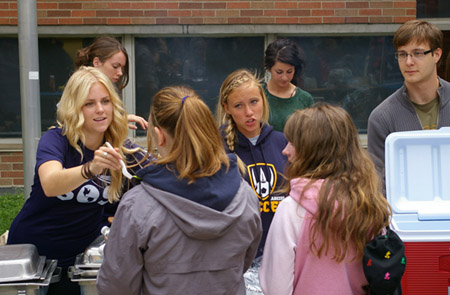 students distributing hotdogs