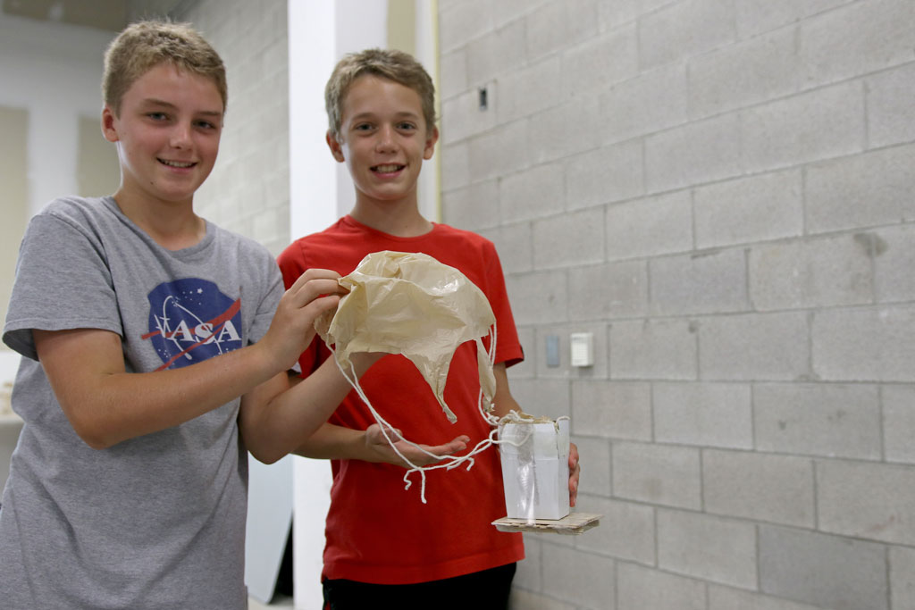 Campers display their apparatus that will safely transport the egg to the ground during the Lancer Engineering Camp on Wednesday.