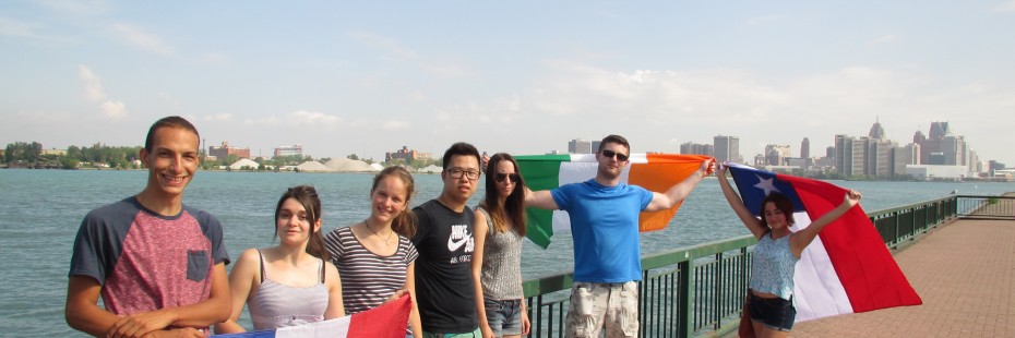 Students pose with flags down at the riverfront