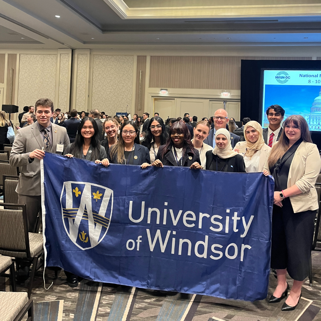 Picture of the UWill Discover Team holding UWindsor flag at the Washington DC National Model United Nations event