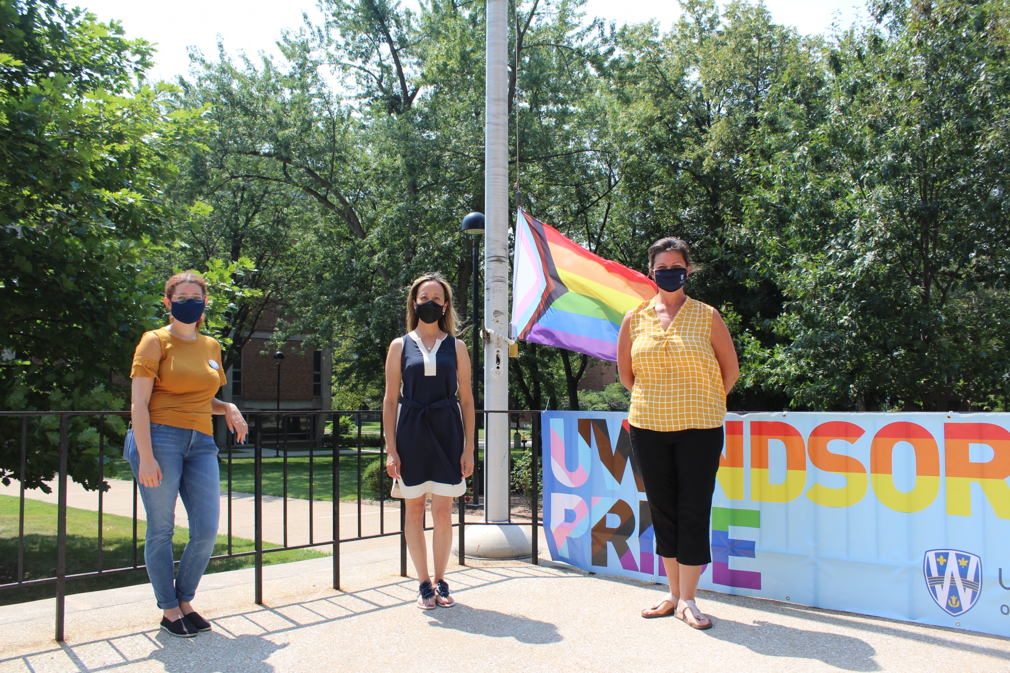 members of Student Success and VP Academic pose with progress pride flag and UWindsor Pride Banner