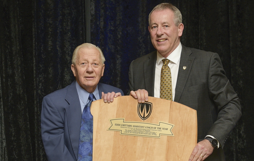 Eddi Chittaro, BA ’55, MA ’58 (left) former chair, Alumni Sports Hall of Fame committee, is honoured for his years of service by Athletics’ Director Mike Havey. (Ted Kloske photo)