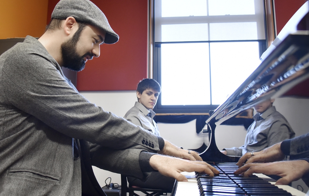 Jazz/contemporary piano instructor Michael Karloff demonstrates “cross hand” technique to his student Alex Aideira-Leite