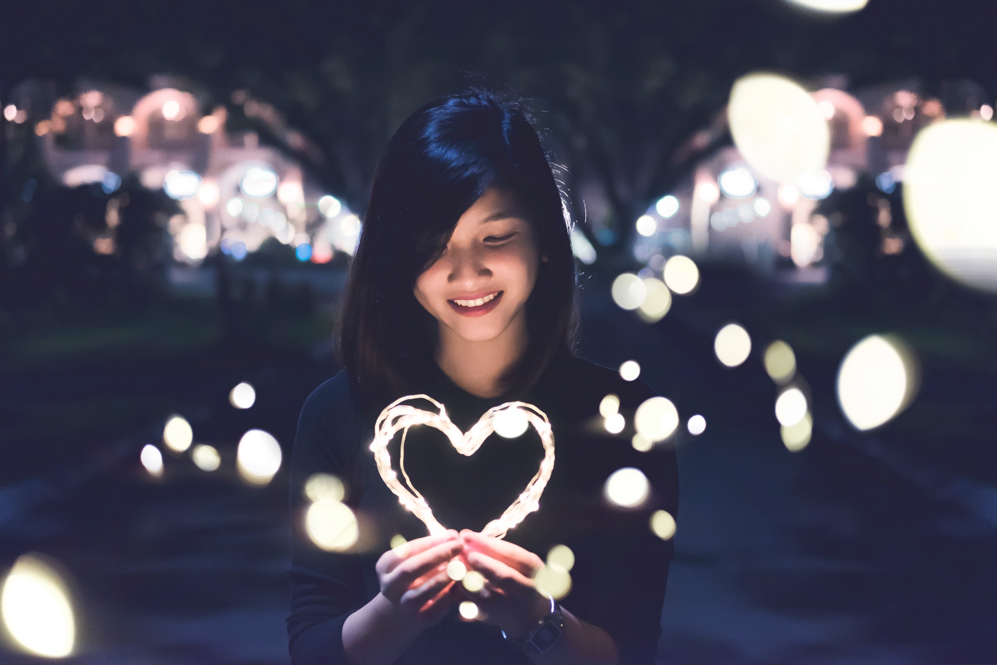 Young adult with heart-shaped string of lights