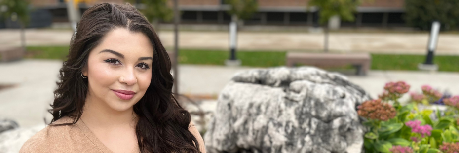 Victoria sitting on a rock in River Commons